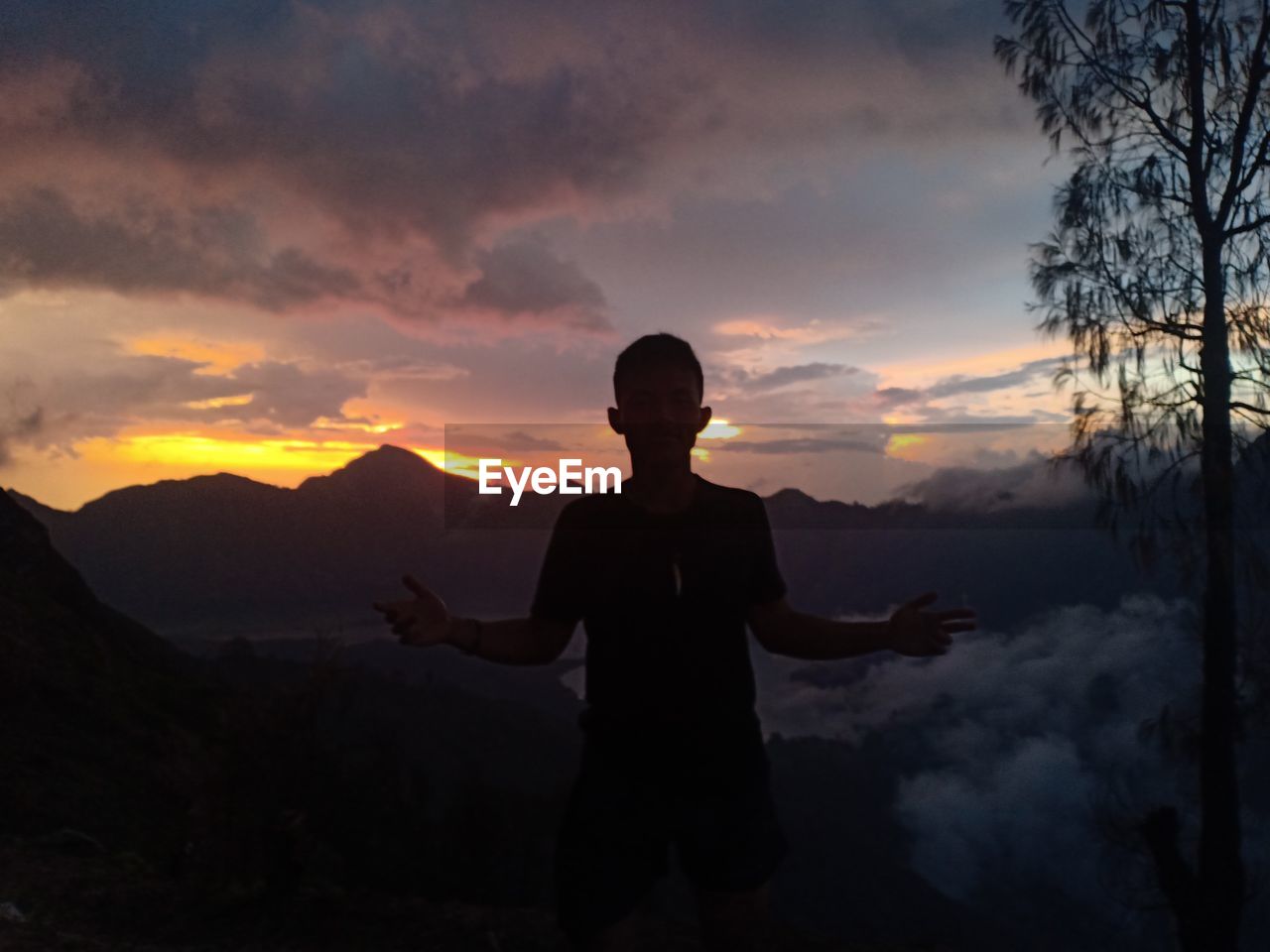 SILHOUETTE MAN STANDING AGAINST ORANGE SKY