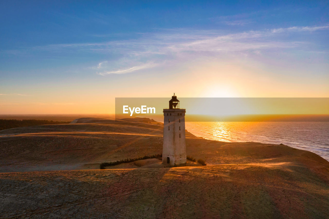 Rubjerg knude fyr lighthouse in sunset from drone