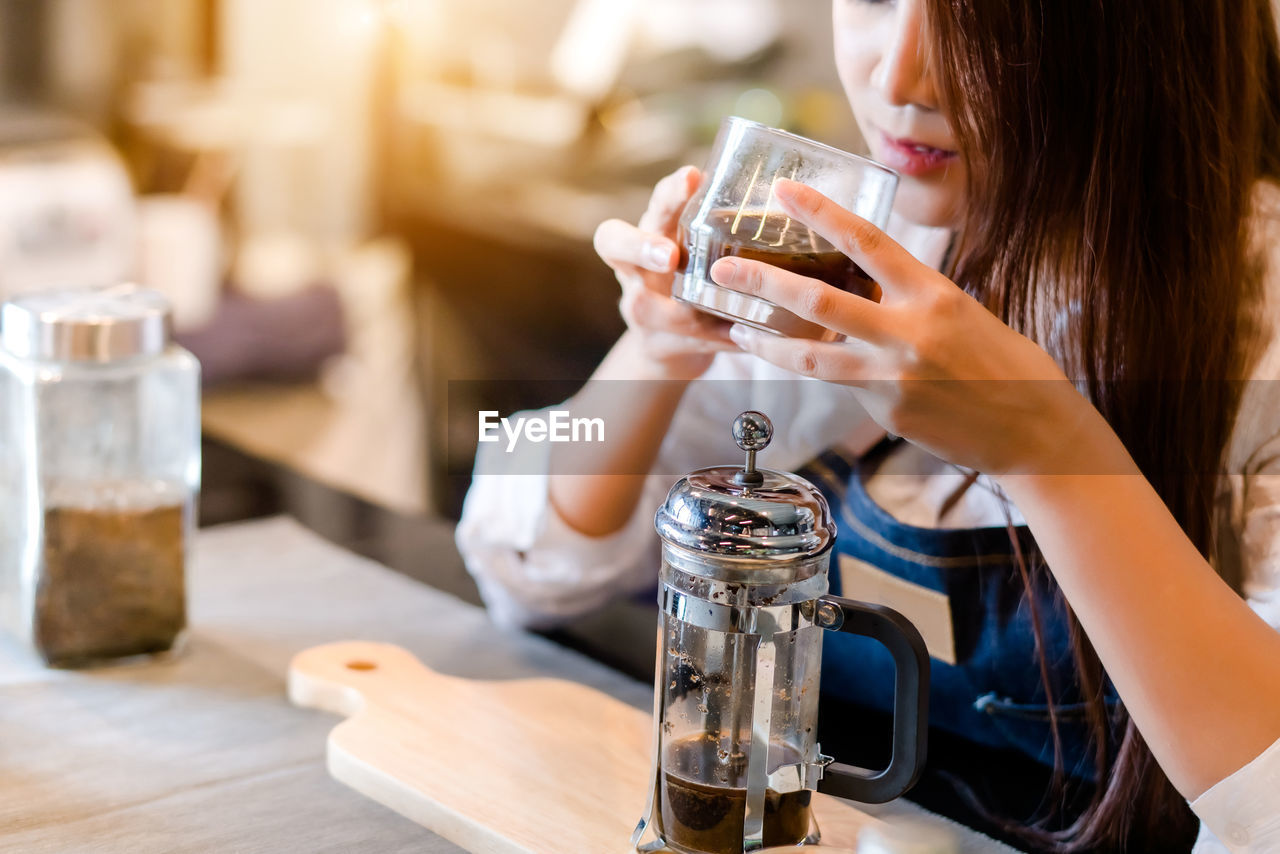 MIDSECTION OF WOMAN DRINKING GLASS WITH WINE