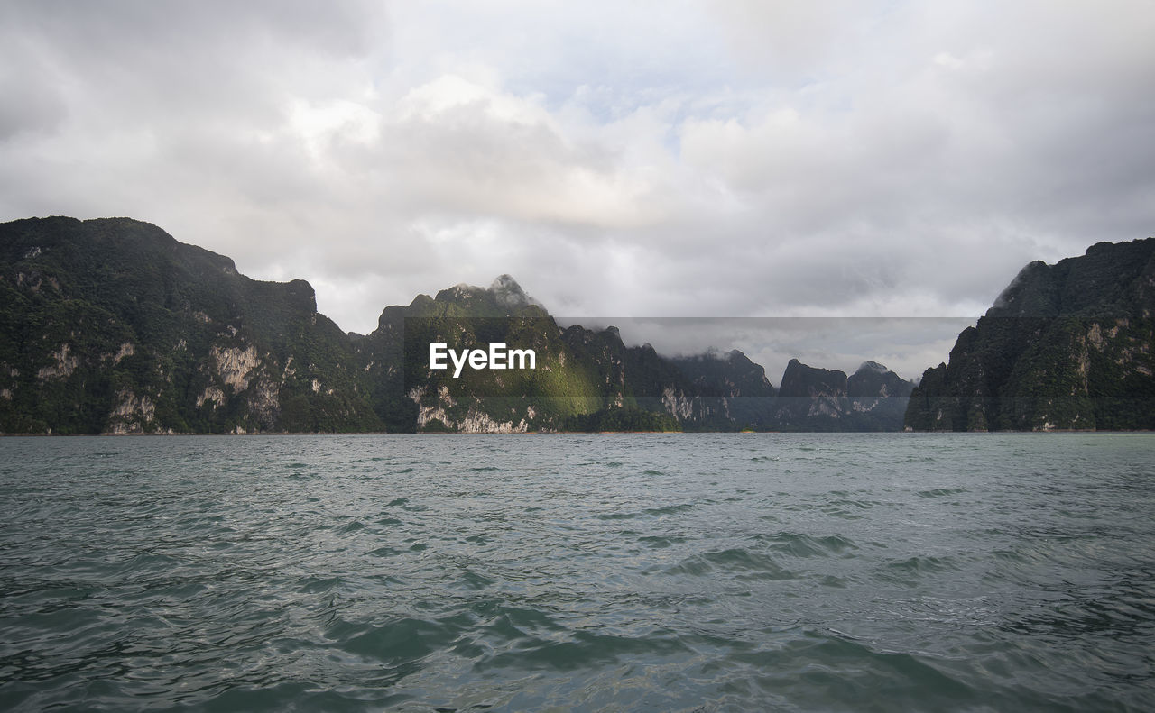 Scenic view of sea and mountains against sky