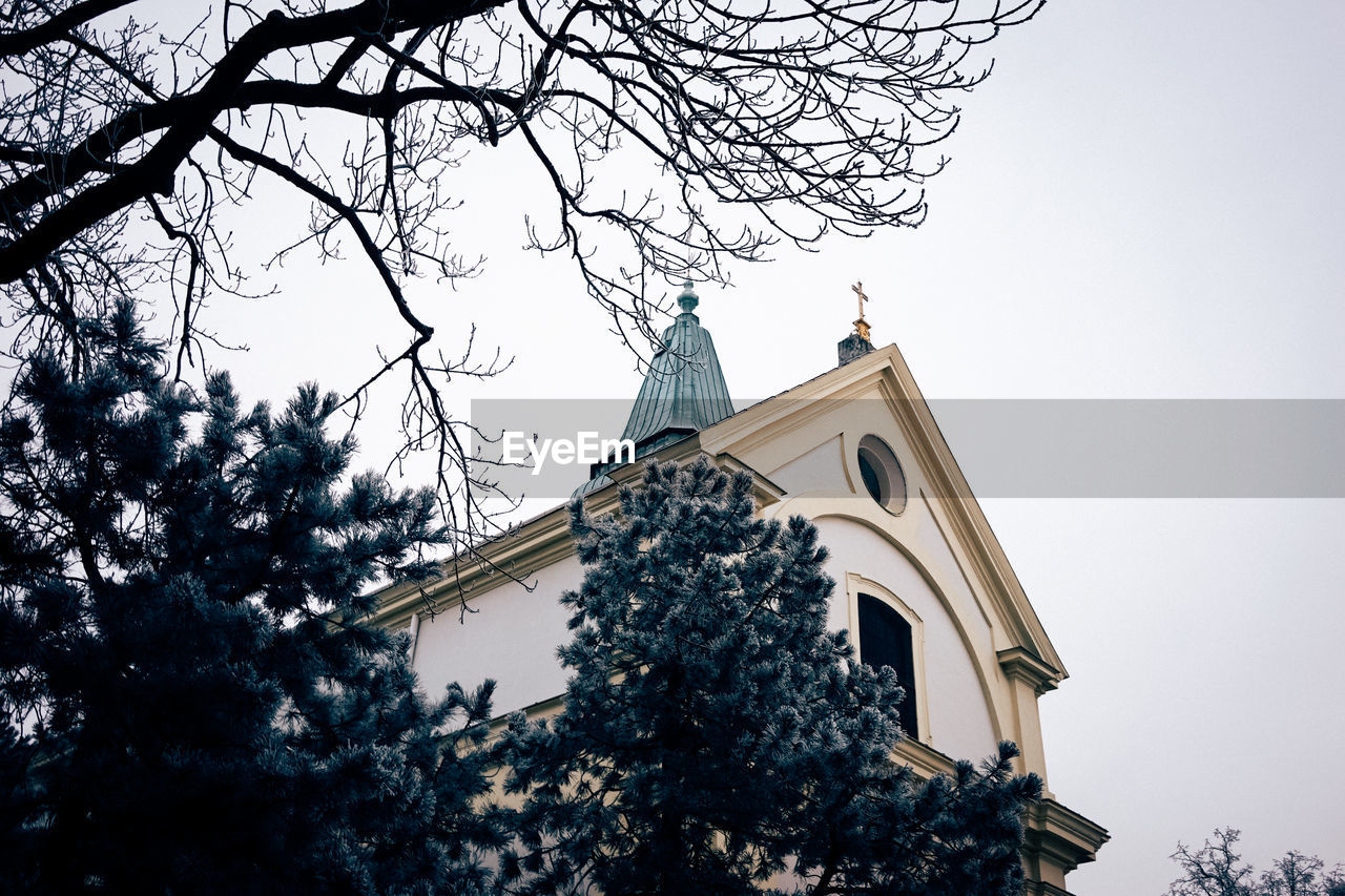 LOW ANGLE VIEW OF CHURCH WITH TREES IN BACKGROUND