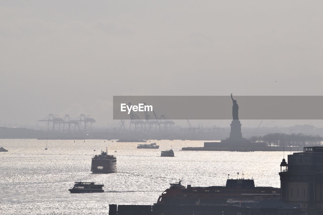 Silhouette statue of liberty in hudson river against sky