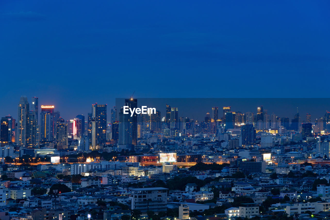 Illuminated cityscape against sky at night