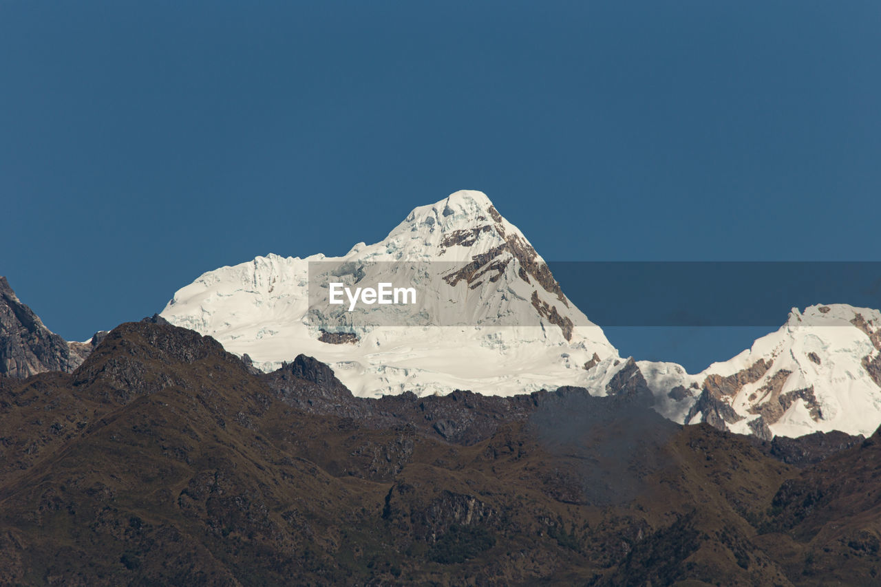 Scenic view of snowcapped mountains against clear blue sky