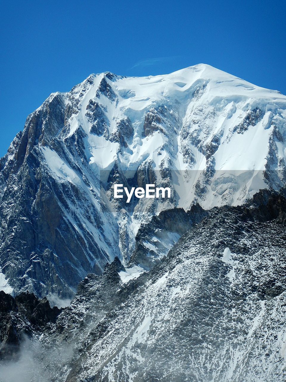 Scenic view of snowcapped mountains against clear blue sky