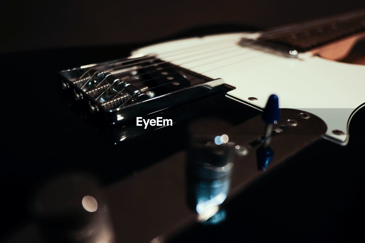 CLOSE-UP OF GUITAR ON TABLE AT HOME