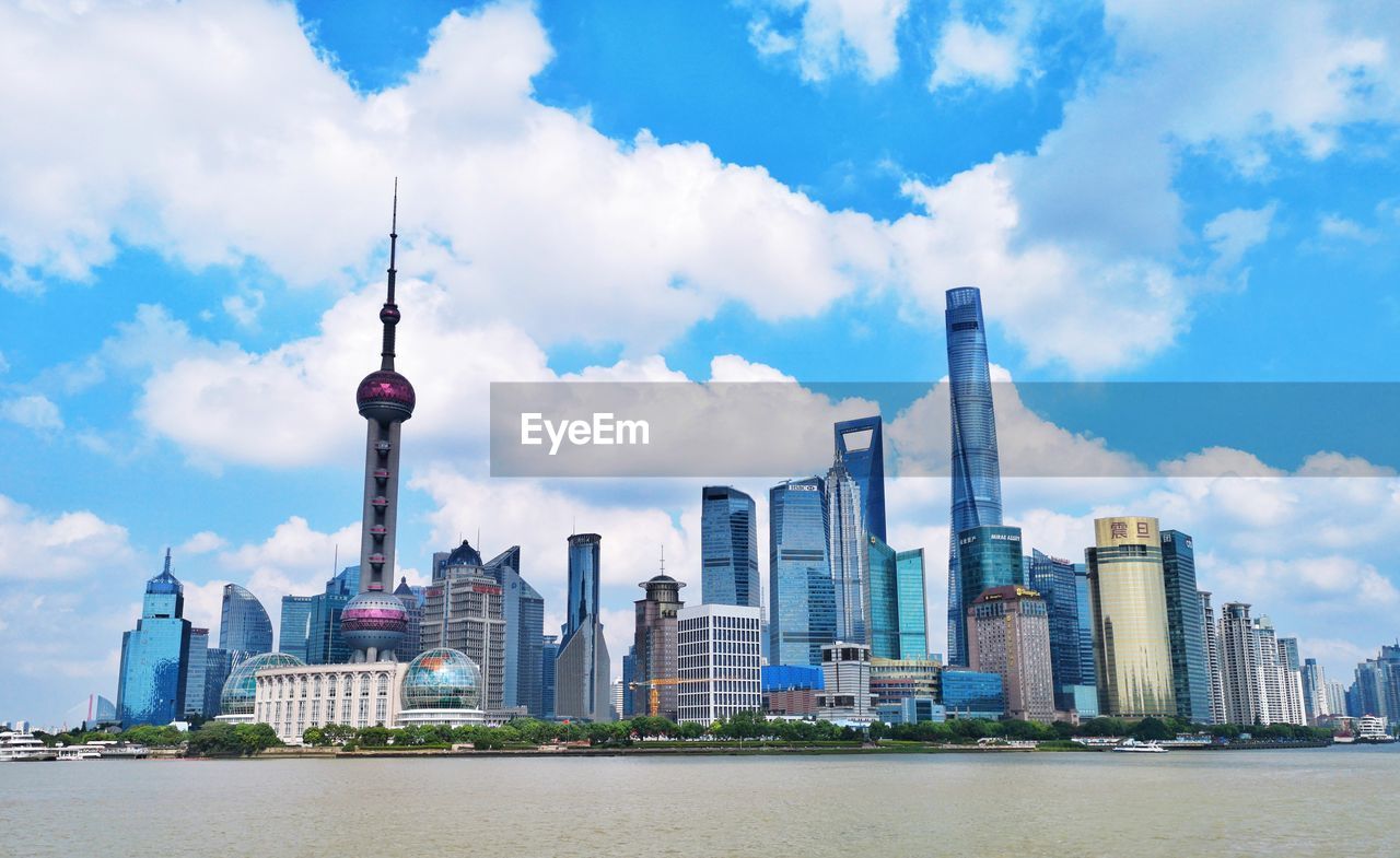 CITY BUILDINGS AGAINST CLOUDY SKY