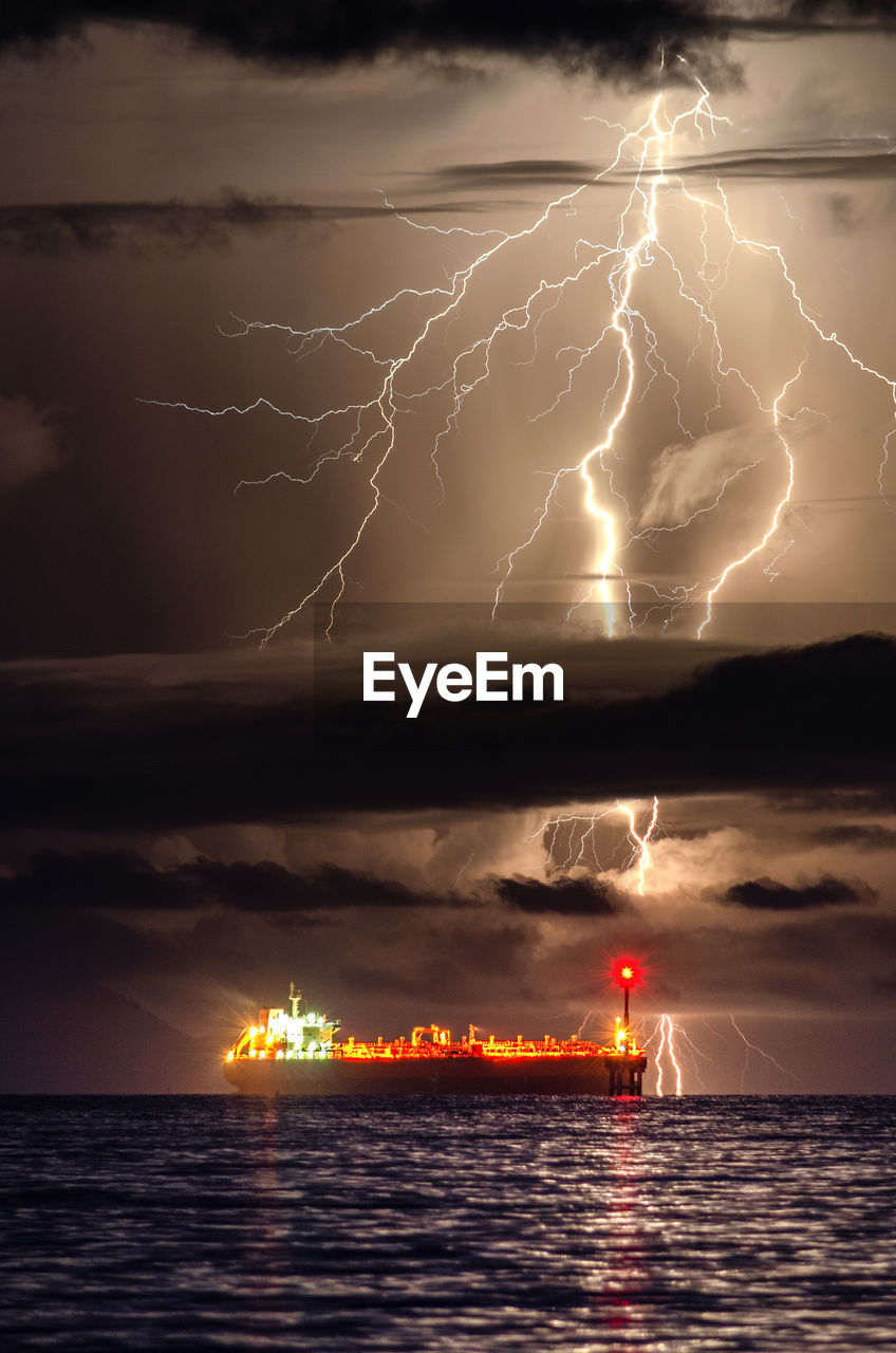 LIGHTNING OVER SEA AGAINST STORM CLOUDS