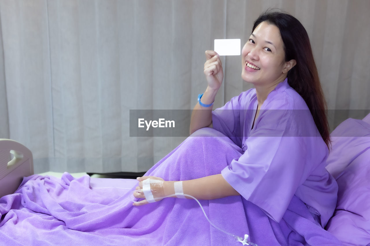 Female patient is smiling and showing blank credit card. healthcare and insurance concept.