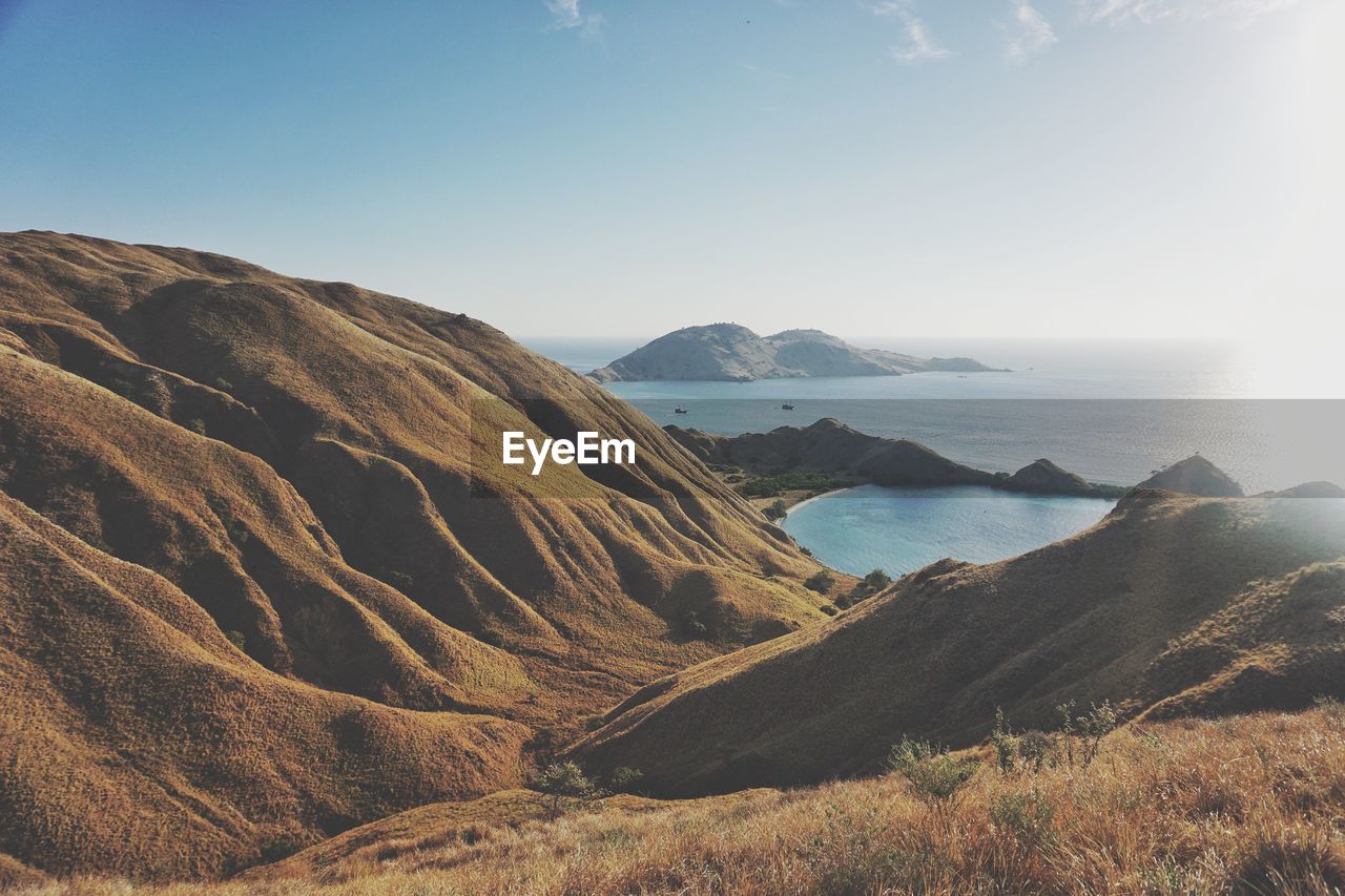 Scenic view of sea and mountains against sky