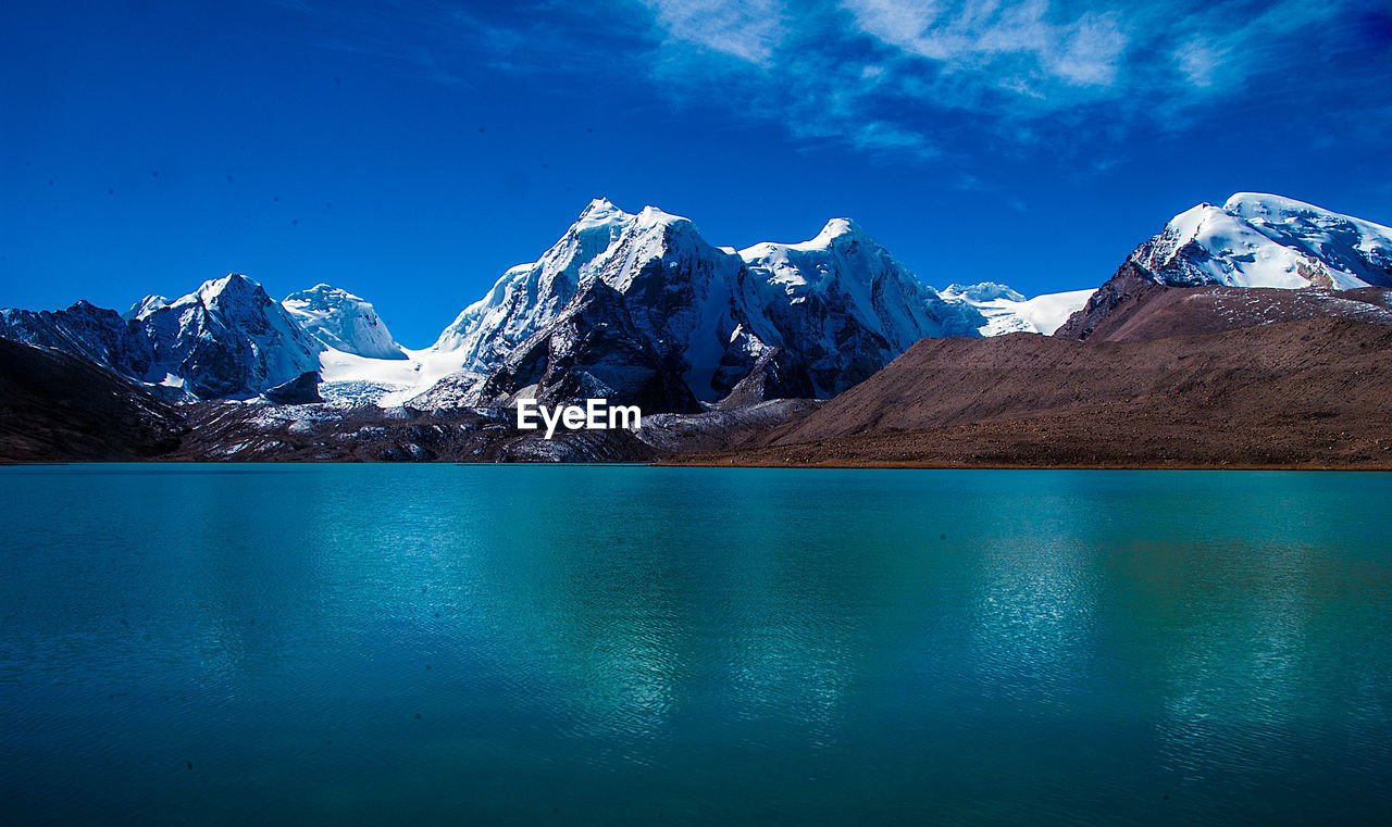 SCENIC VIEW OF LAKE AND SNOWCAPPED MOUNTAINS AGAINST SKY DURING WINTER