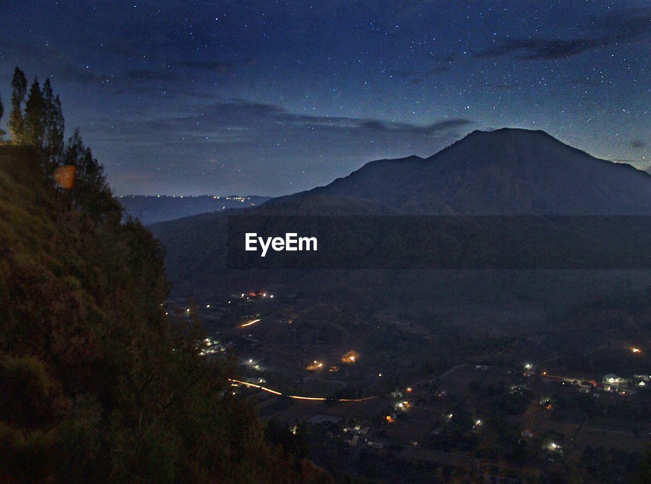 ILLUMINATED MOUNTAINS AGAINST SKY AT NIGHT