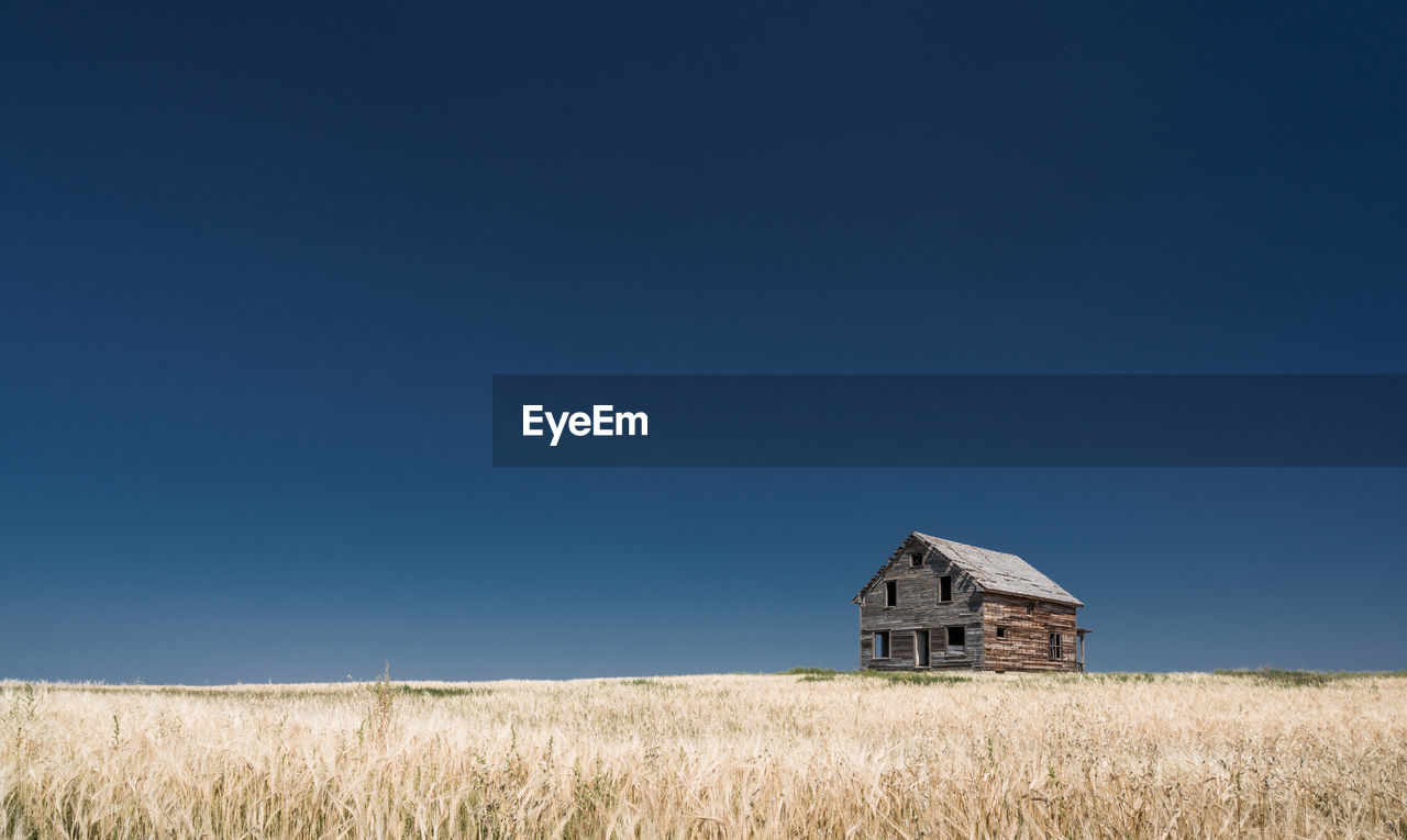 BUILT STRUCTURE ON FIELD AGAINST CLEAR SKY