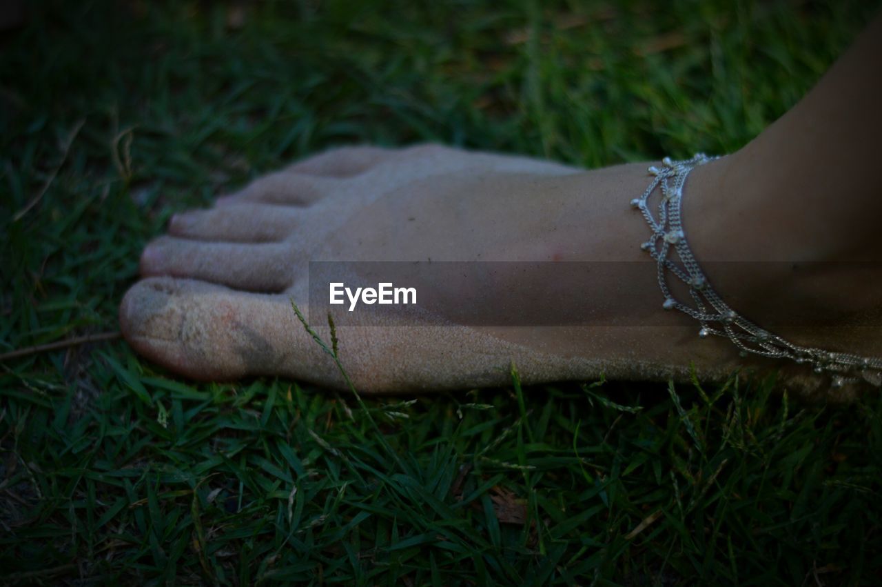 Low section of woman standing on grassy field