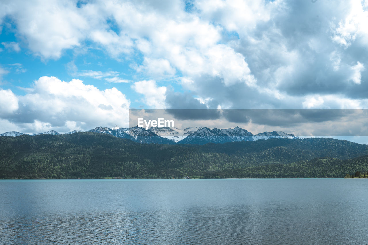 Scenic view of lake by mountains against sky