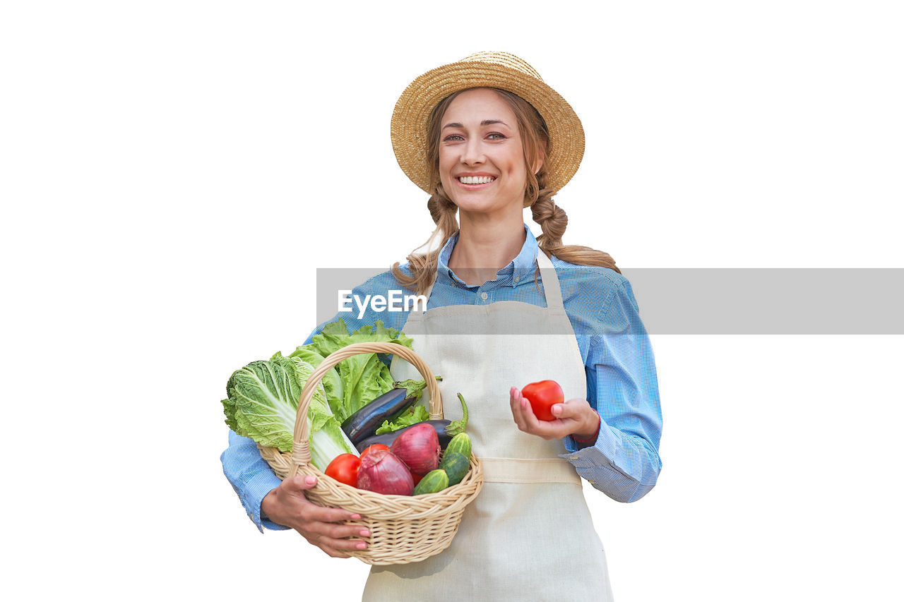 PORTRAIT OF SMILING YOUNG WOMAN HOLDING BASKET