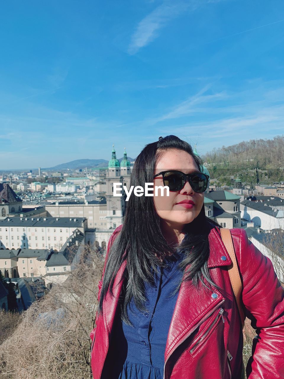 PORTRAIT OF YOUNG WOMAN WEARING SUNGLASSES STANDING OUTDOORS