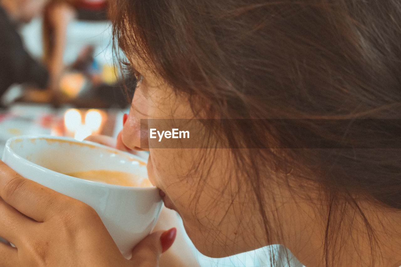 Close-up portrait of a woman drinking coffee