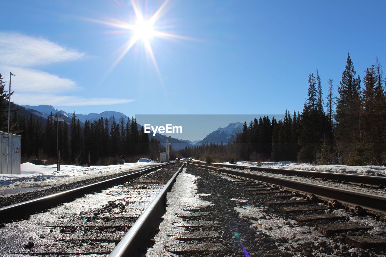 RAILROAD TRACKS IN WINTER AGAINST SKY