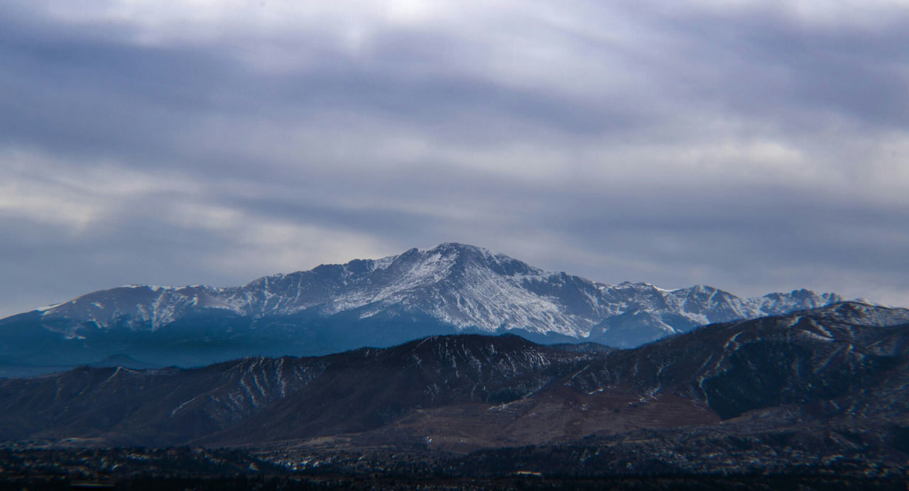 Scenic view of mountains against cloudy sky