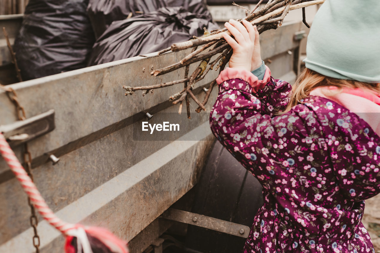 Child collects dry sticks in the trailer to take out with other garbage. 