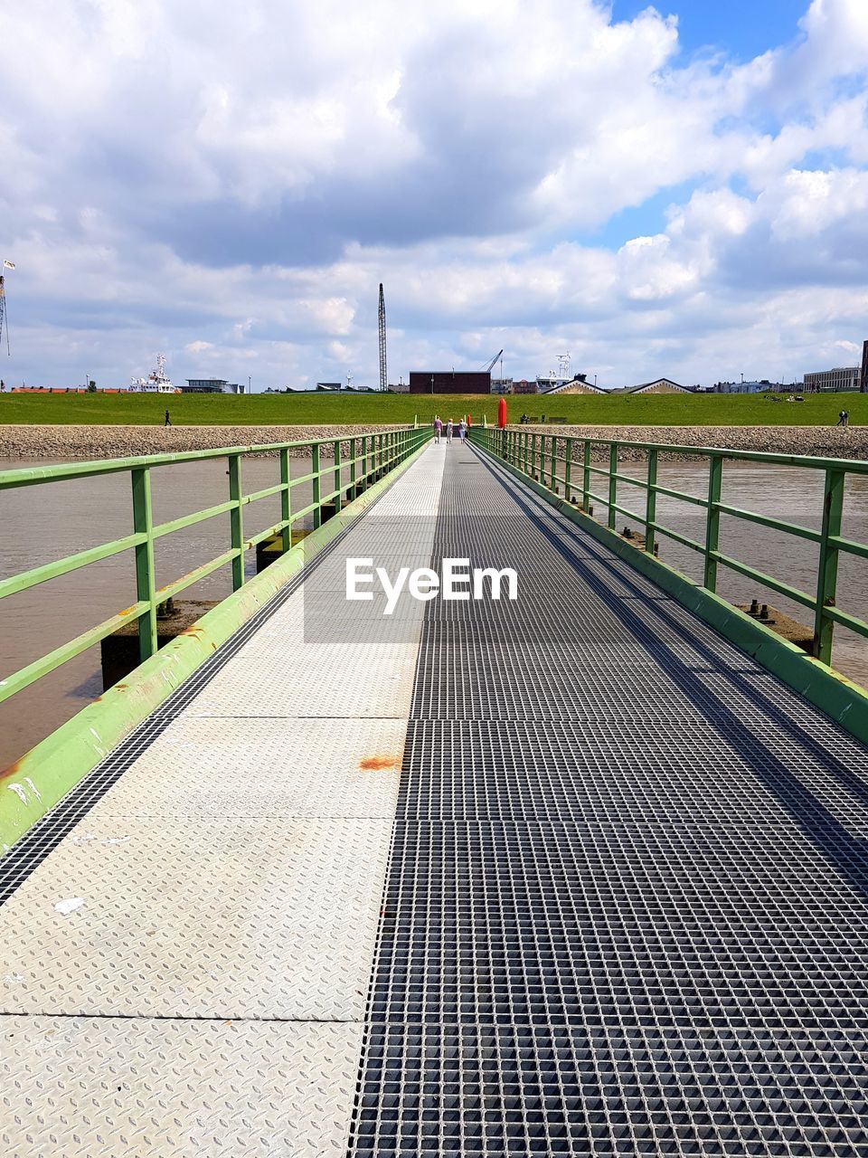 Footbridge over sea against sky