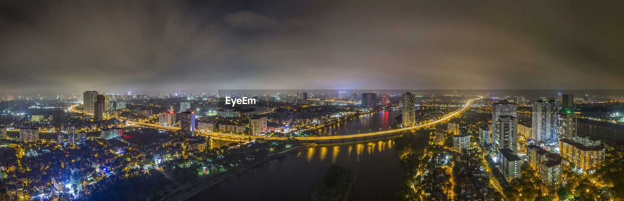 High angle view of illuminated city by river at night