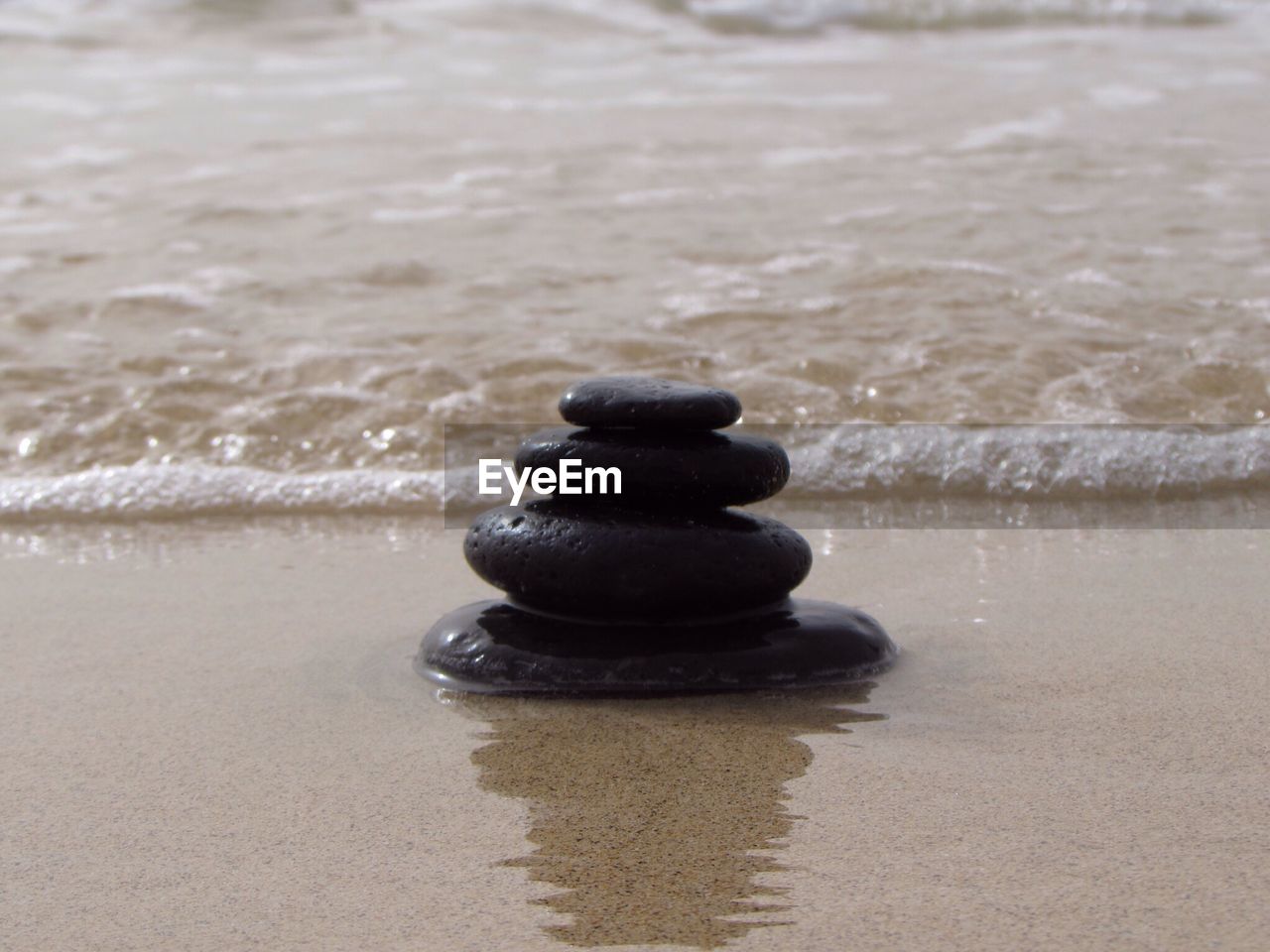 Close-up of stacked pebbles on shore at beach