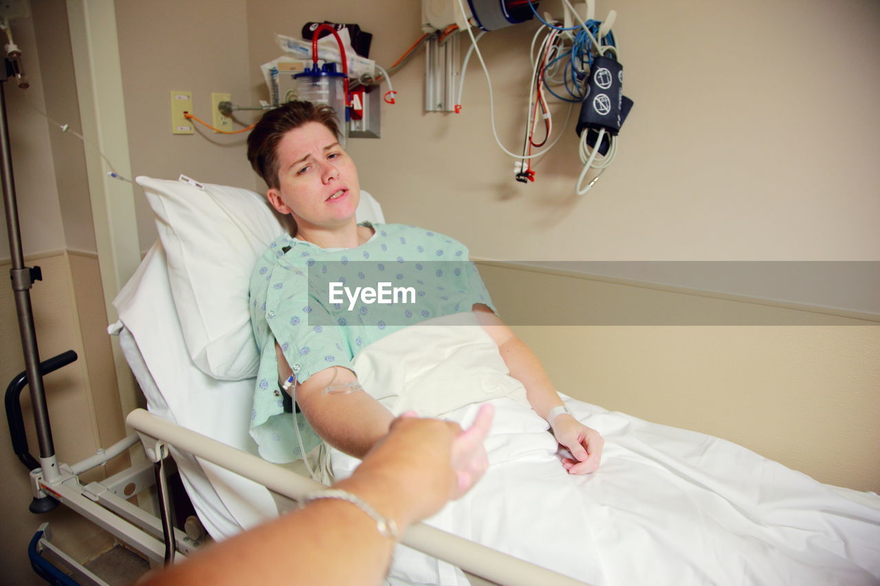 Mid adult woman sitting on hospital bed