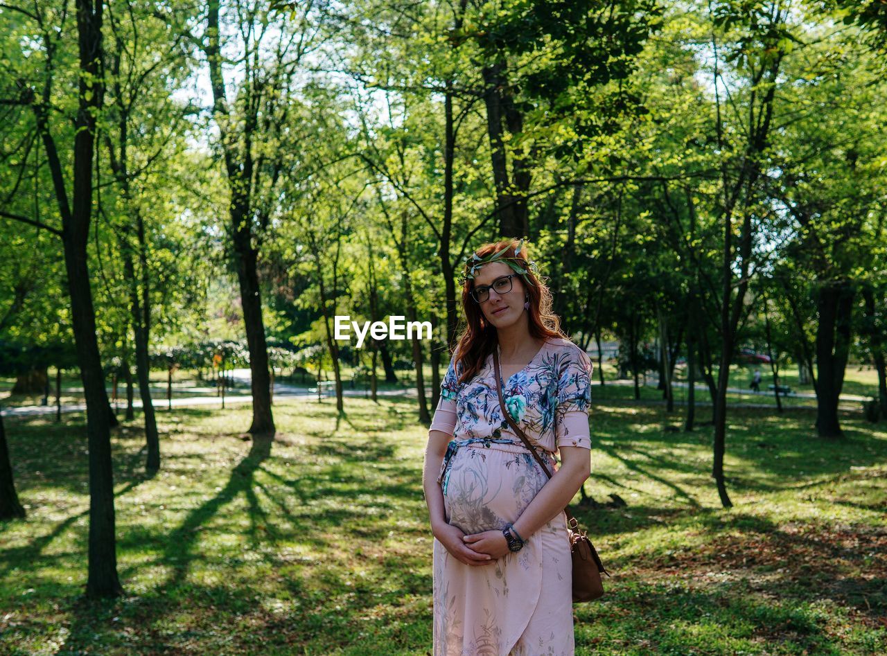 Pregnant woman posing on a filed