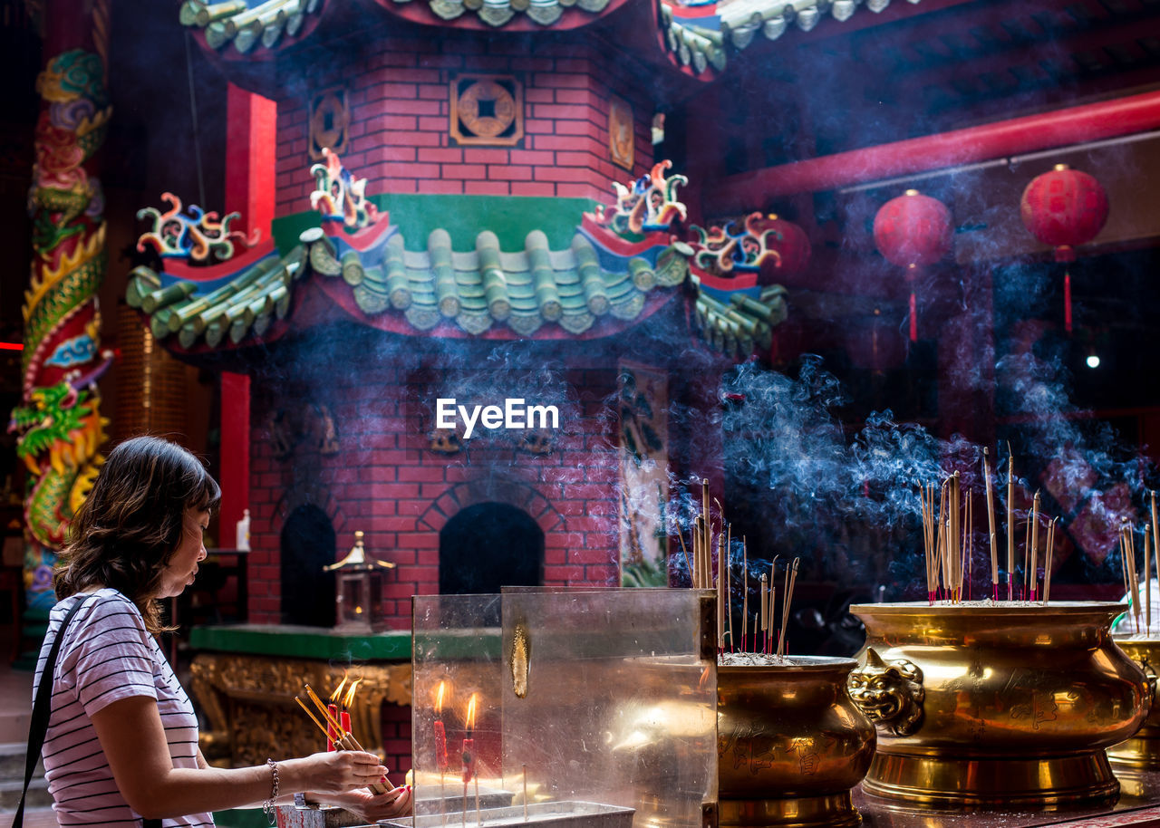 Woman holding incense in temple