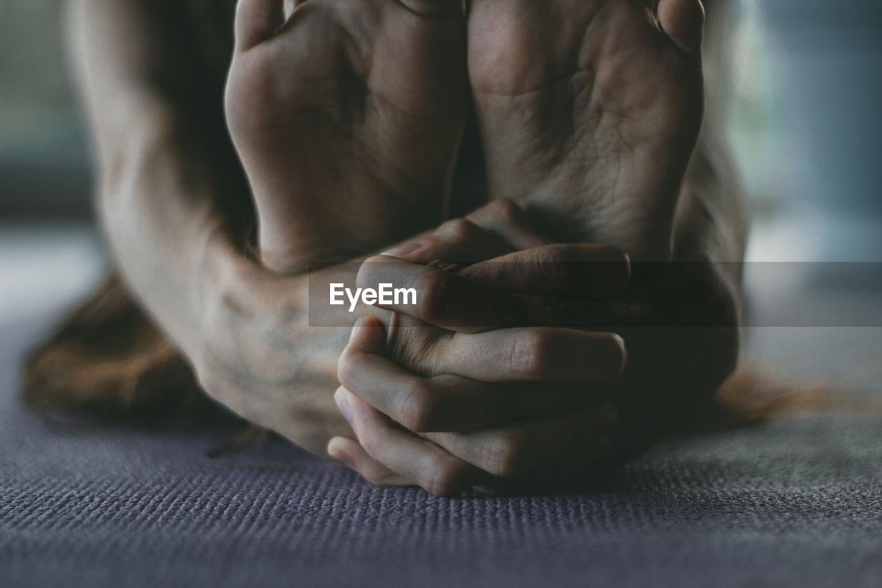 Low section of woman doing yoga at home