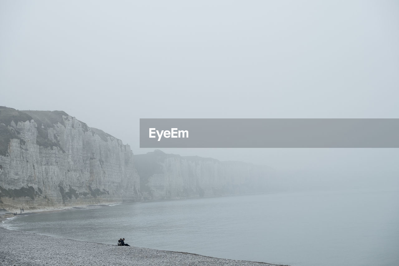 rear view of man walking on sea against sky