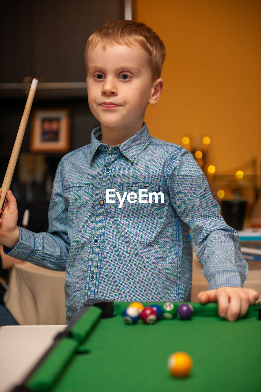Boy playing pool on table