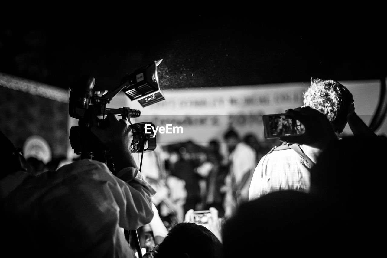 Rear view of photographer with camera during ceremony