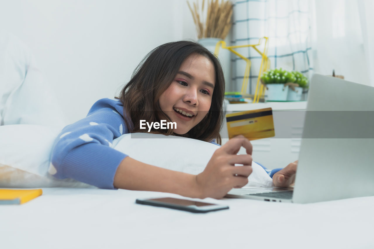 PORTRAIT OF YOUNG WOMAN USING MOBILE PHONE