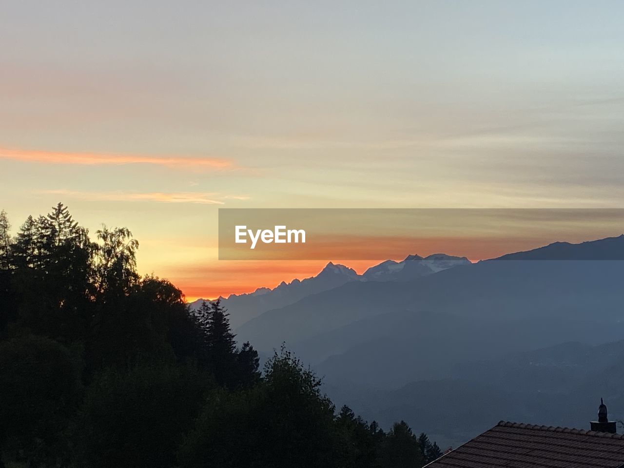 SCENIC VIEW OF MOUNTAINS AGAINST ORANGE SKY