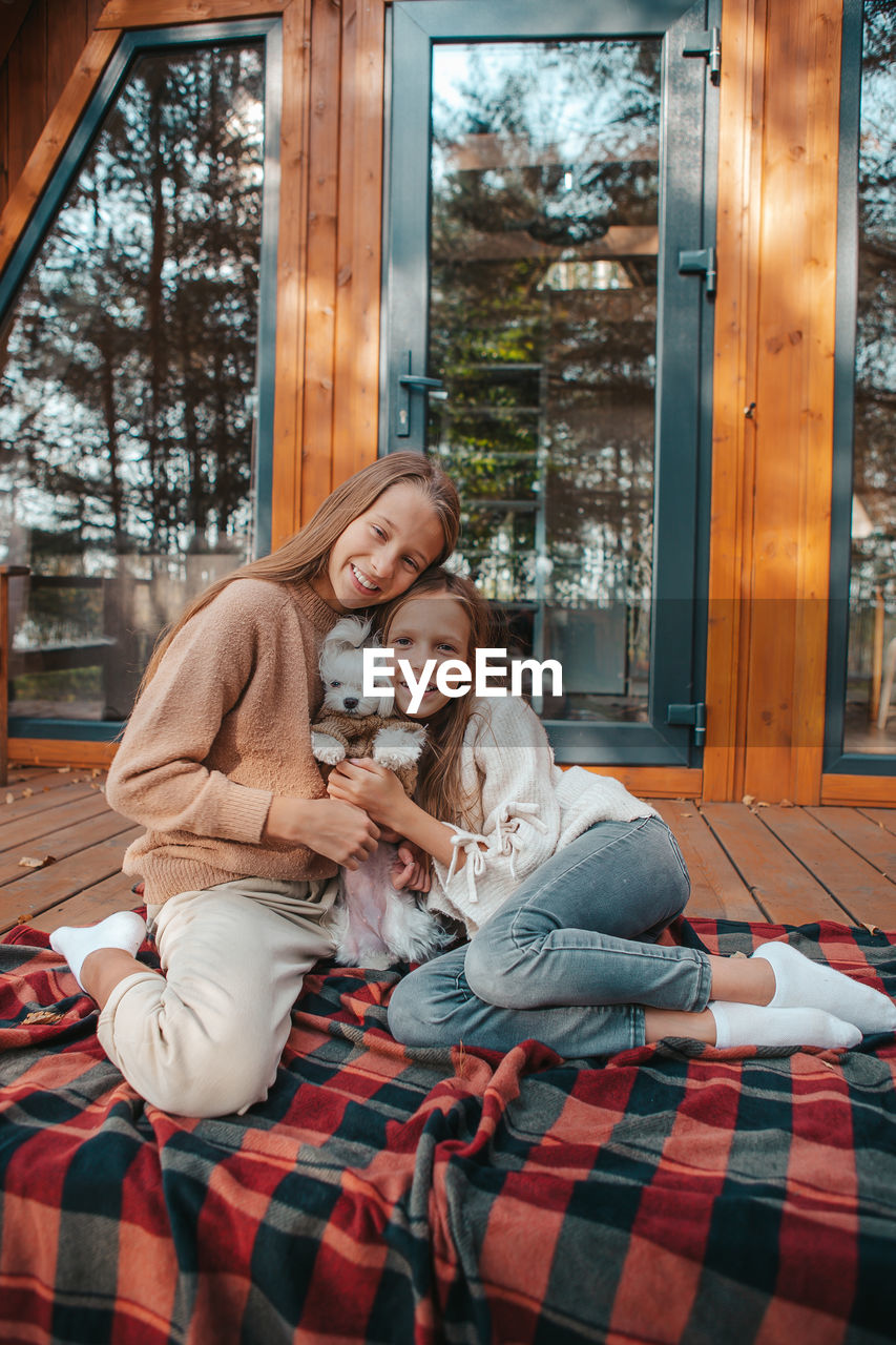 Portrait of happy sisters with dog