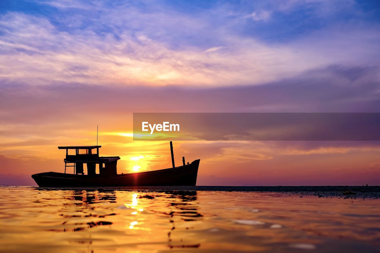 SILHOUETTE BOAT IN SEA AGAINST ORANGE SKY