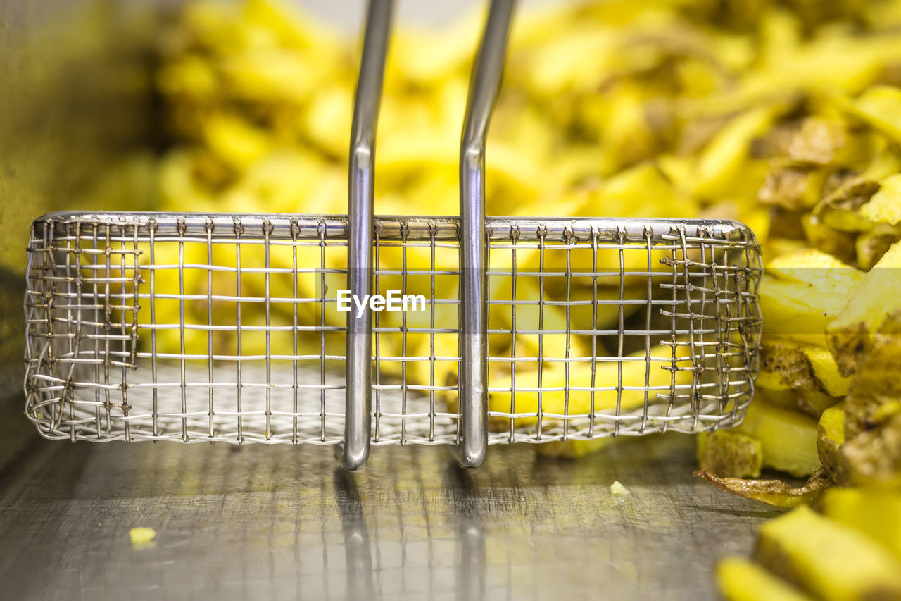 CLOSE-UP OF YELLOW FOOD ON METAL TABLE