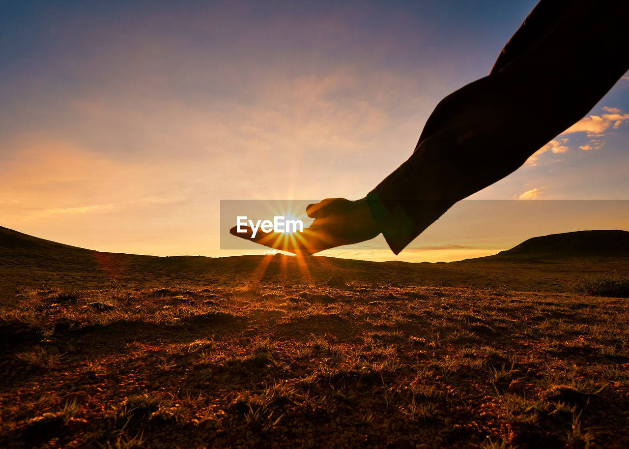 Optical illusion of hand holding sun