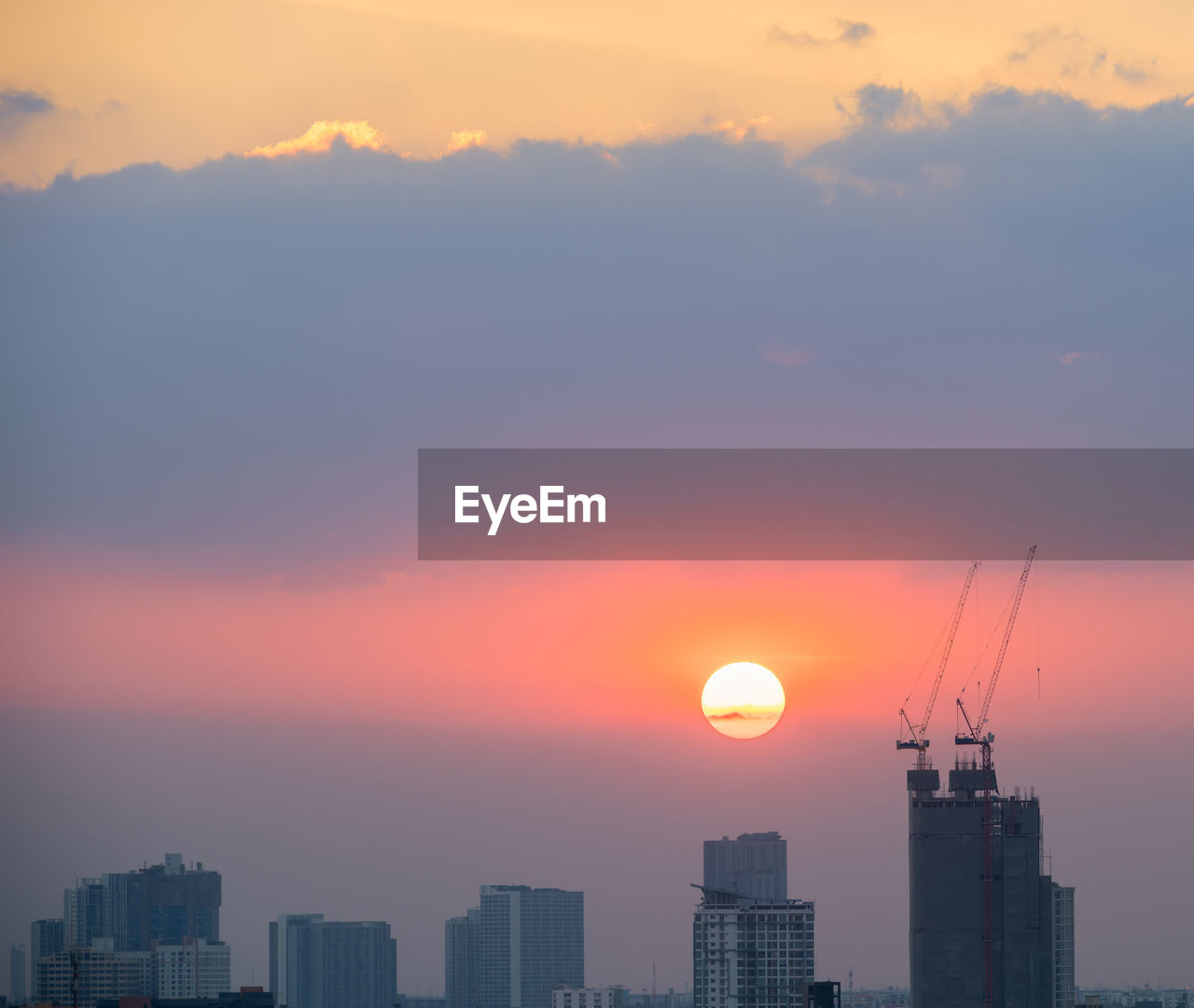 SILHOUETTE BUILDINGS AGAINST ORANGE SKY