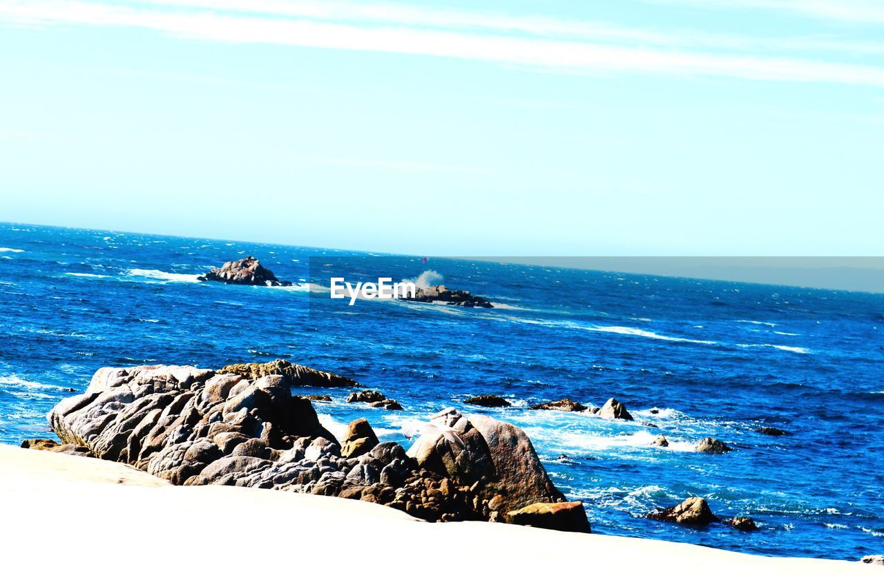 ROCKS ON BEACH AGAINST SKY