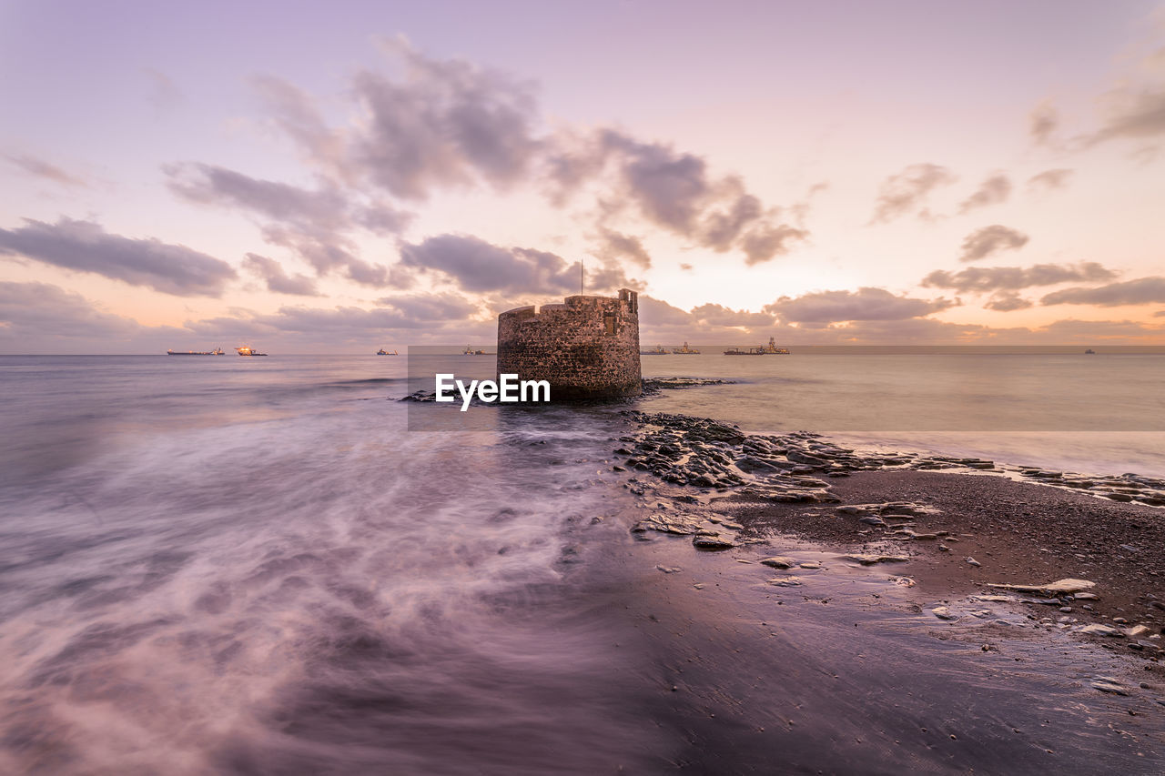 SCENIC VIEW OF BEACH DURING SUNSET