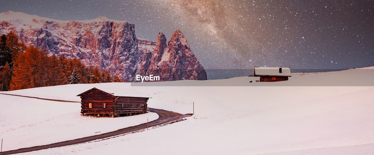 HOUSE ON SNOWCAPPED MOUNTAINS AGAINST SKY