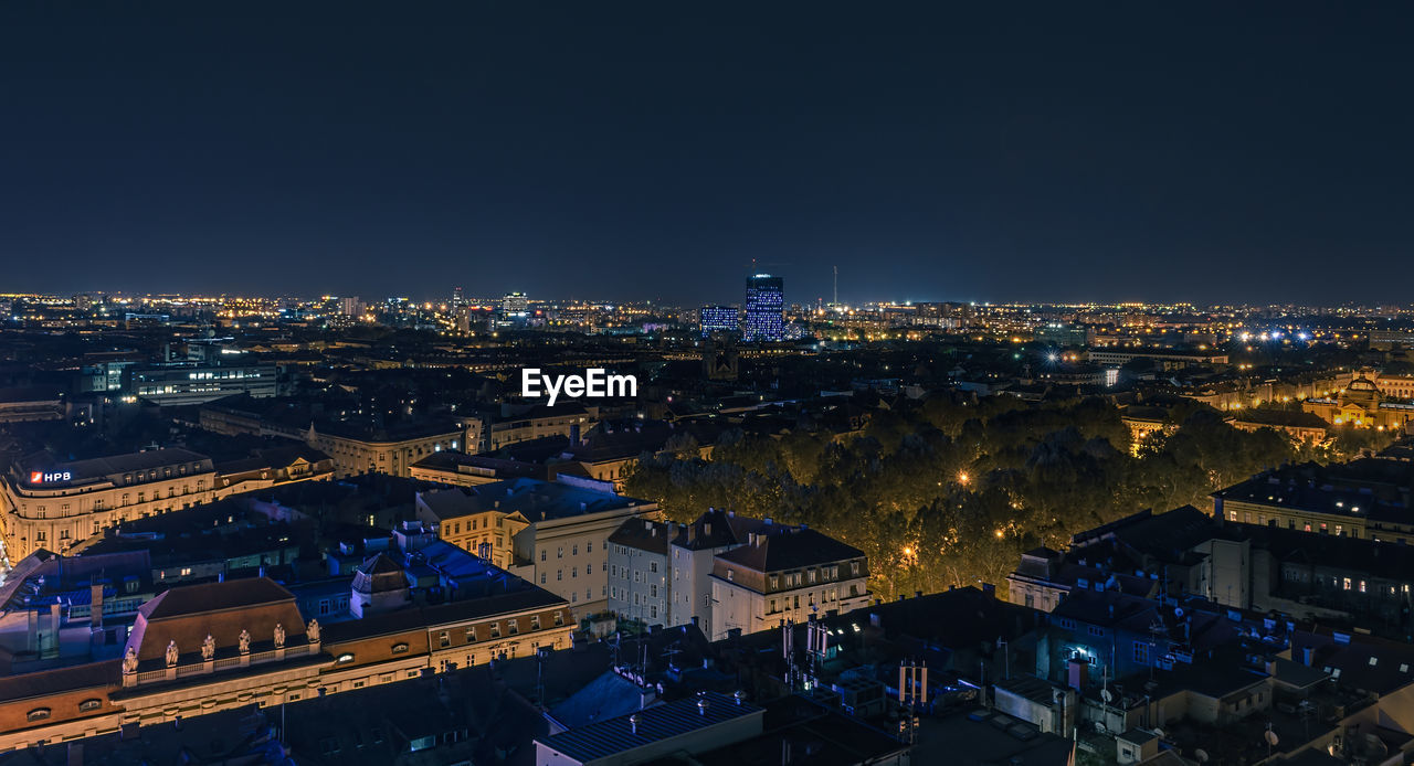 High angle view of illuminated buildings against sky at night