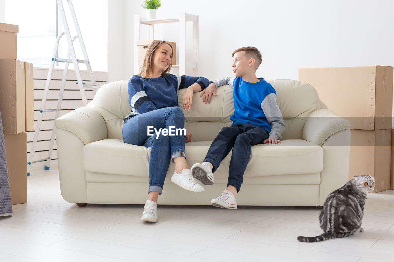 WOMEN SITTING ON SOFA AT HOME