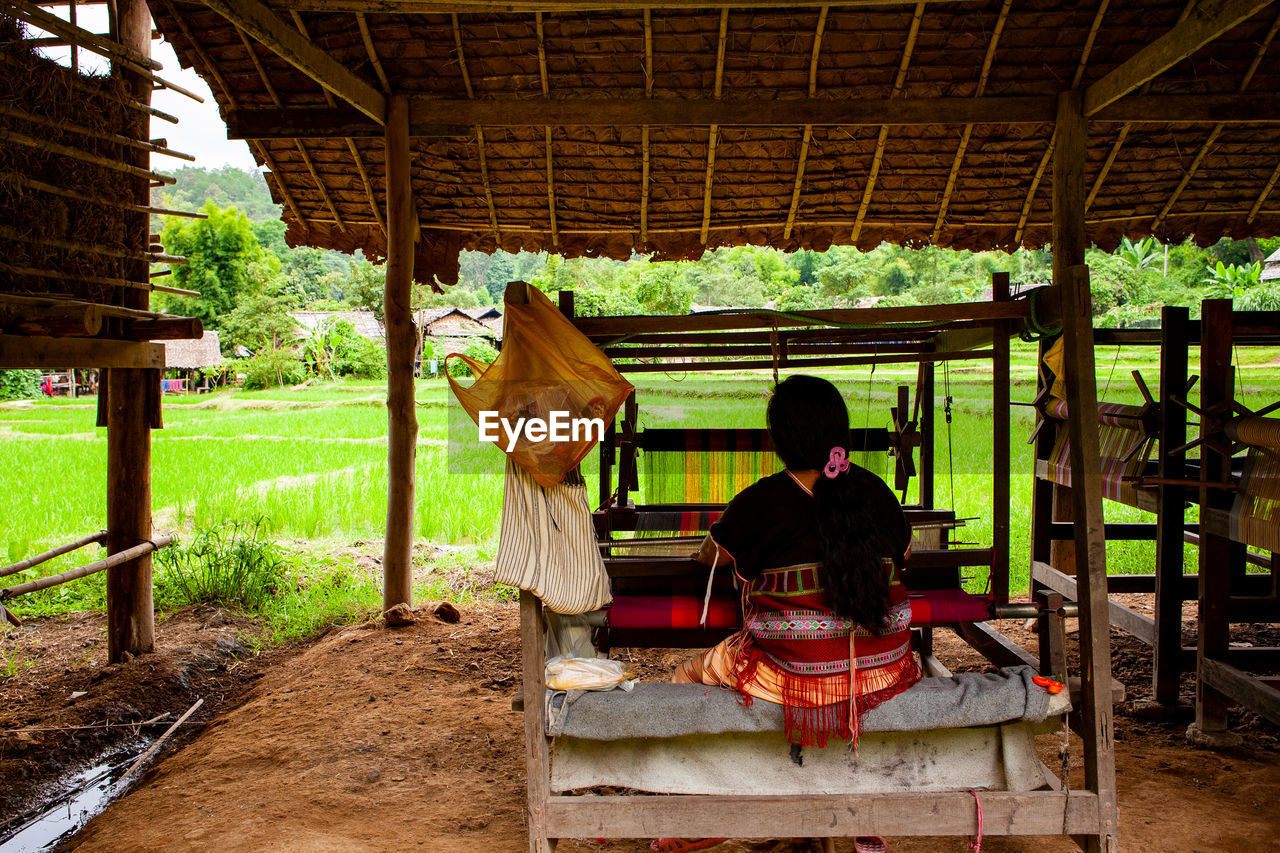 REAR VIEW OF COUPLE SITTING ON CROSS