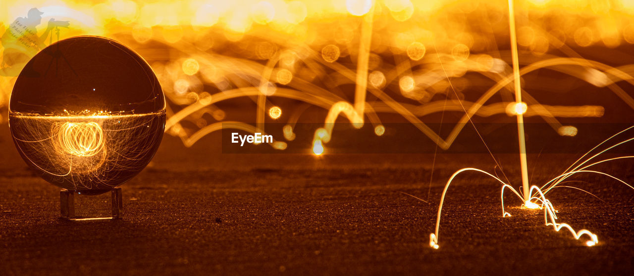 CLOSE-UP OF ILLUMINATED LIGHT PAINTING ON FIRE