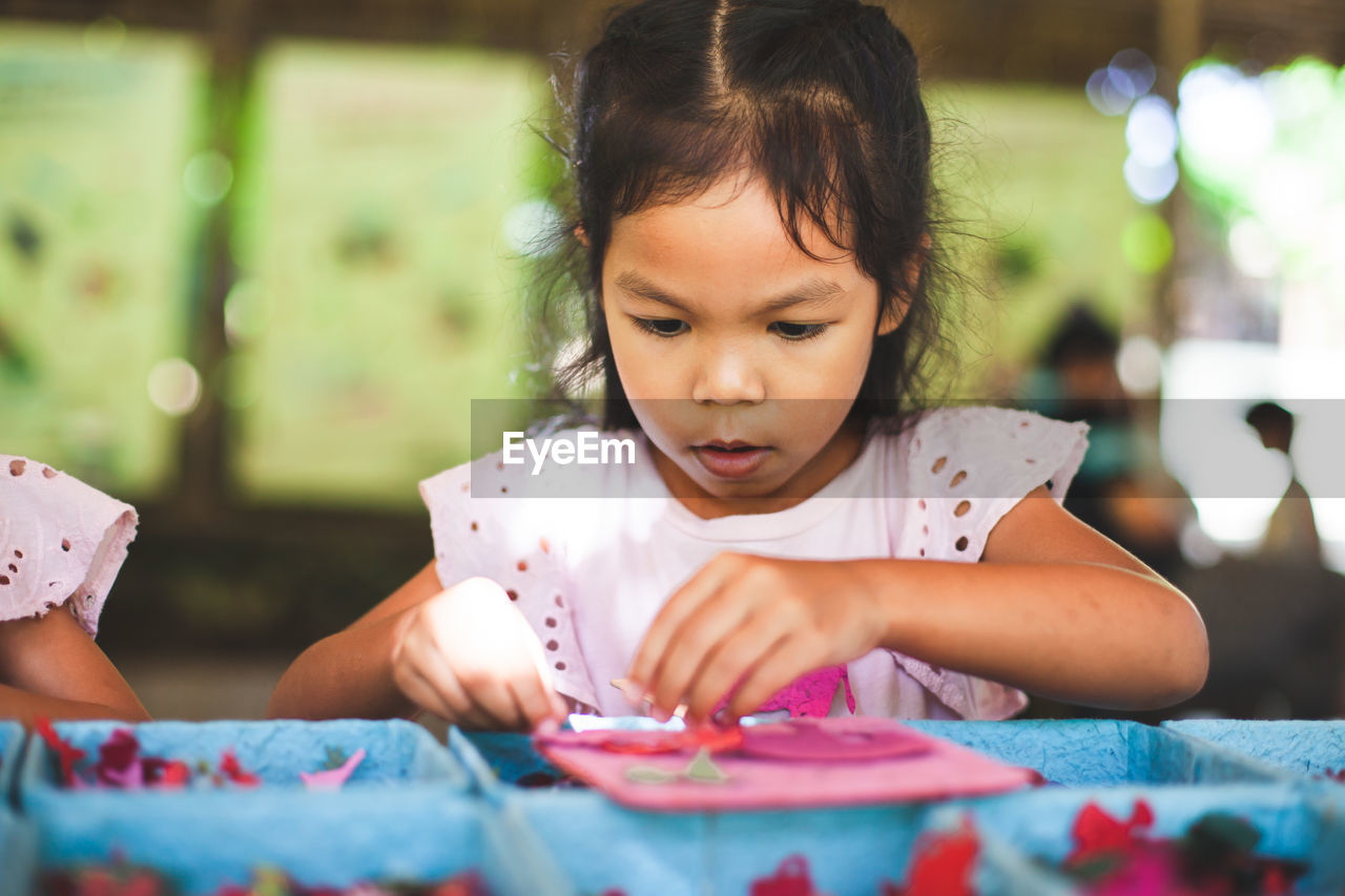 Close-up of cute girl making artwork at workshop